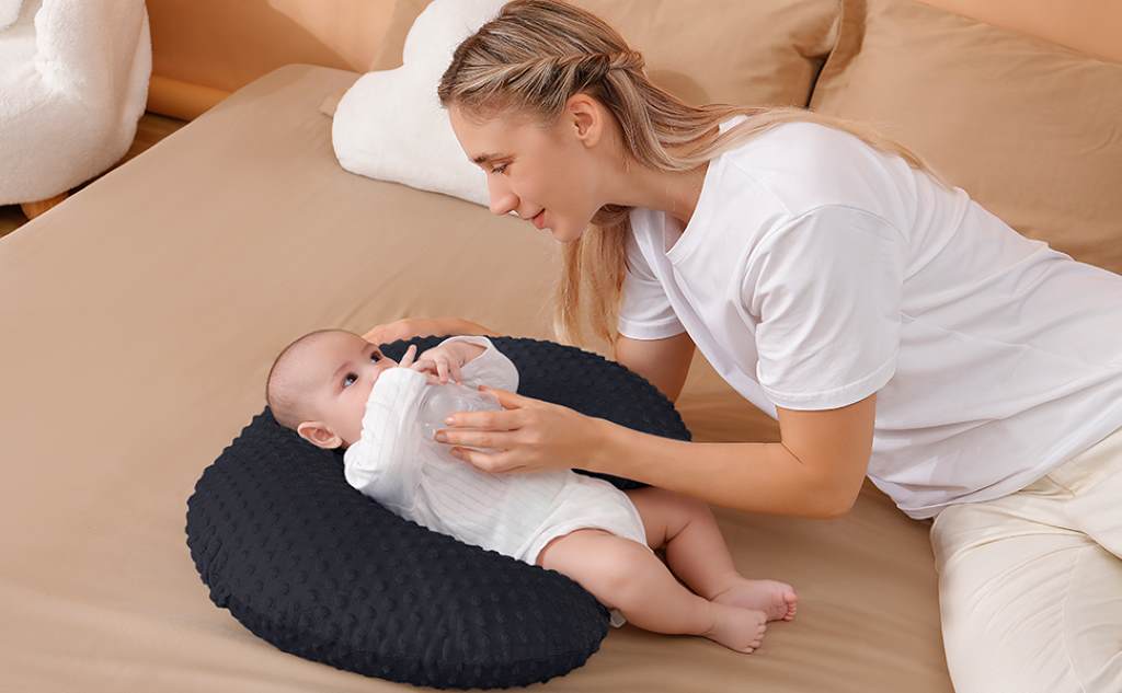 Side view of a multifunctional breastfeeding pillow used for tummy time, with a toddler propped comfortably on its firm, ergonomic shape.