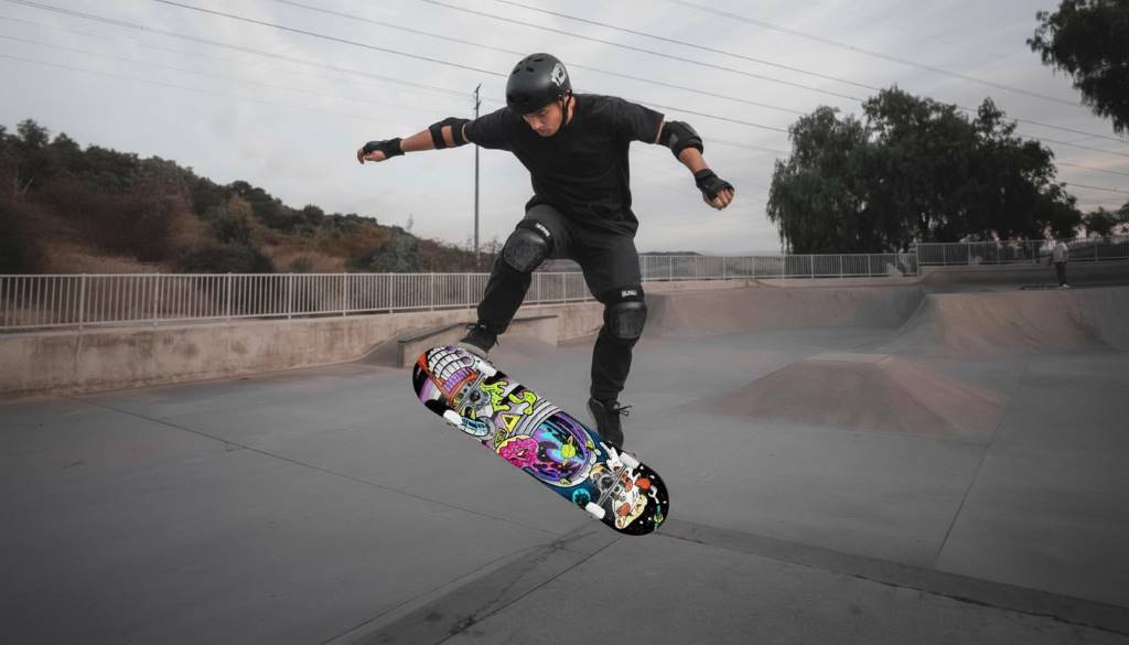 New skater wearing full safety gear practicing on flat ground